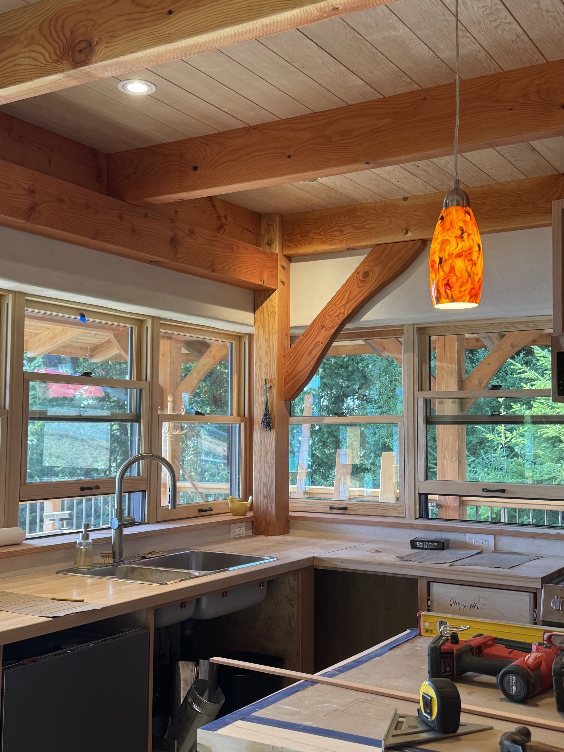 Timber-frame kitchen with exposed Douglas-fir beams over a working kitchen